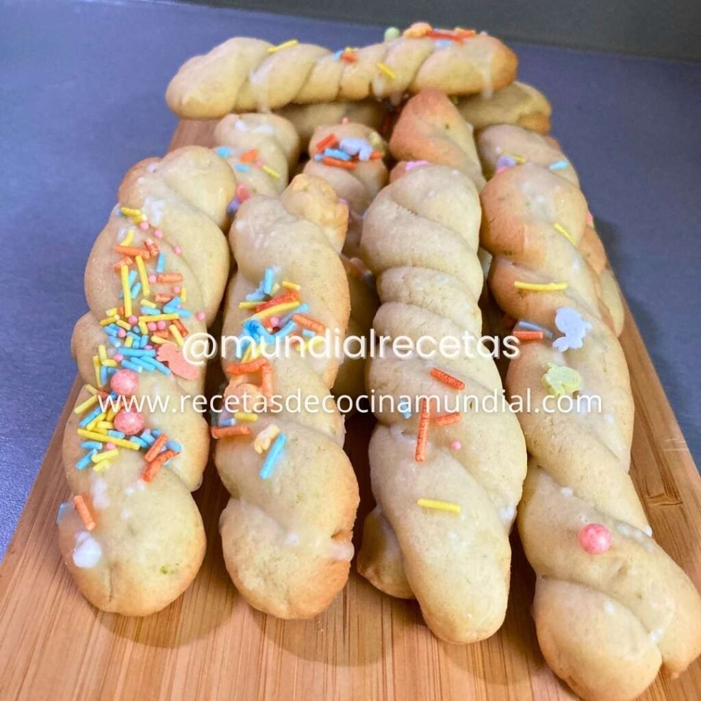 Galletas trenzadas de limón con glaseado y sprinkles sobre tabla de madera