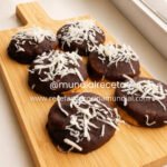 Galletas de coco caseras con cobertura de chocolate decoradas con coco rallado.