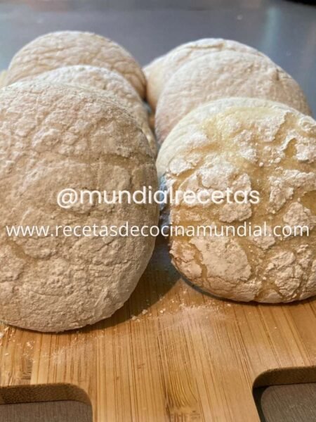 Galletas craqueladas de limón caseras con cobertura de azúcar glas sobre una tabla de madera, listas para servir.